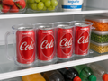 Suporte organizador de latas com 4 latas de refrigerante na geladeira